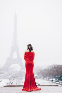 Rear view of woman standing tower during winter