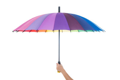 Cropped hand of woman holding umbrella against white background