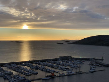 High angle view of townscape by sea against sky during sunset