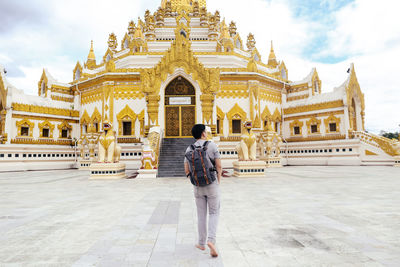 Man standing outside temple against sky