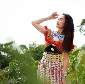 Woman wearing traditional clothing while standing amidst plants on field