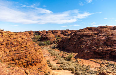 Rock formations on landscape against cloudy sky