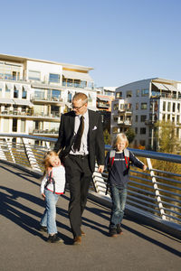 Father and children walking on footbridge