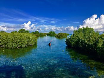 Person kayaking in sea against sky