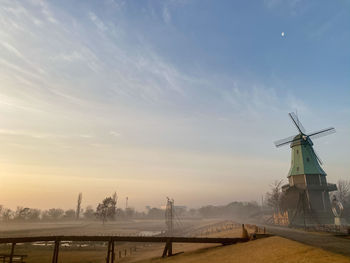 Windmill against sky during sunrise