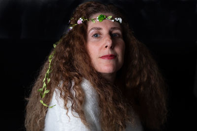 Portrait of woman against black background