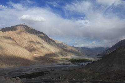 Scenic view of mountains against cloudy sky