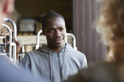 Confident mid adult worker looking at mature colleagues at warehouse