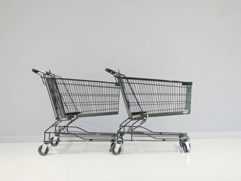 Close-up of shopping carts against gray wall