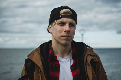 Portrait of young man standing at sea shore