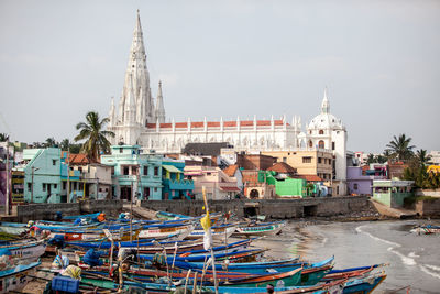 Boats moored at beach with steeple in background