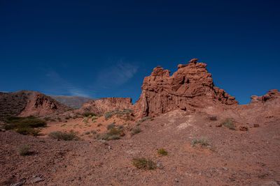 Rock formations in desert against blue sky