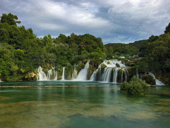 Scenic view of waterfall against sky