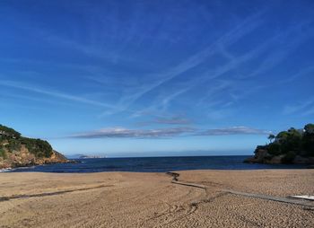 Scenic view of beach against blue sky