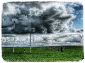 Scenic view of grassy field against cloudy sky