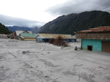 Houses and buildings on mountain against sky