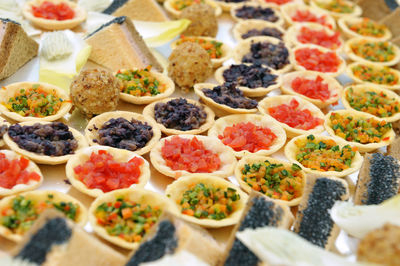 Full frame of savory canapés with colored vegetables