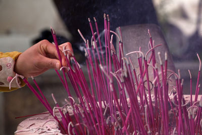 Cropped hand of woman burning incense stick