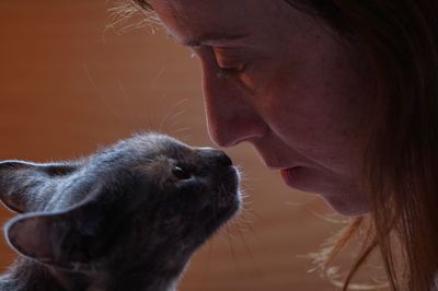 Close-up of mature woman face to face with cat