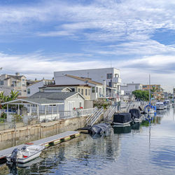 Boats moored in river against buildings in city