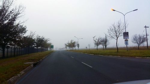 Empty road with trees in background