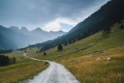 Road leading towards mountains against sky