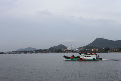 Ferry boat sailing in river against sky