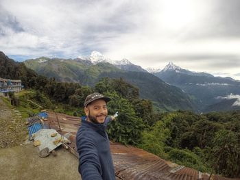 Young man in mountains against sky