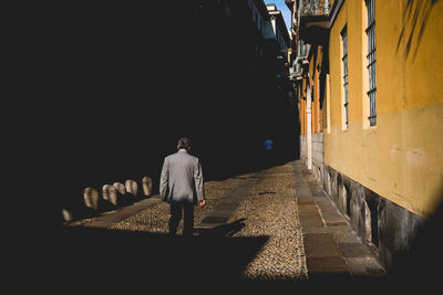 Rear view of man walking on street in city