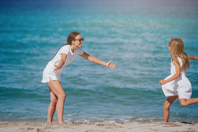 Side view of woman exercising at beach