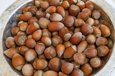 Close up shelled hazelnuts in metal bowl