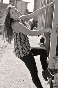 Portrait of woman climbing freight train on sunny day