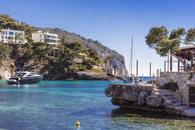 View of swimming pool by buildings against clear sky