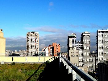 Buildings in city against blue sky