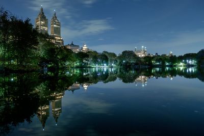 Reflection of buildings in lake at night
