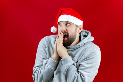 Midsection of man wearing hat against red background