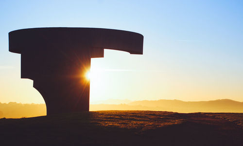 Scenic view of silhouette mountains against clear sky during sunset