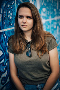 Portrait of young woman standing against blue sky