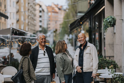 Happy male and female friends enjoying together at street