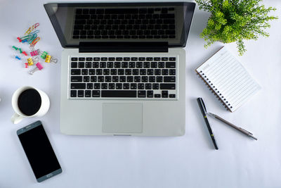 Directly above shot of laptop and coffee cup on table