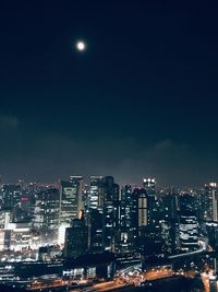 Illuminated buildings against sky at night