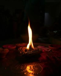 Close-up of lit candle in the dark