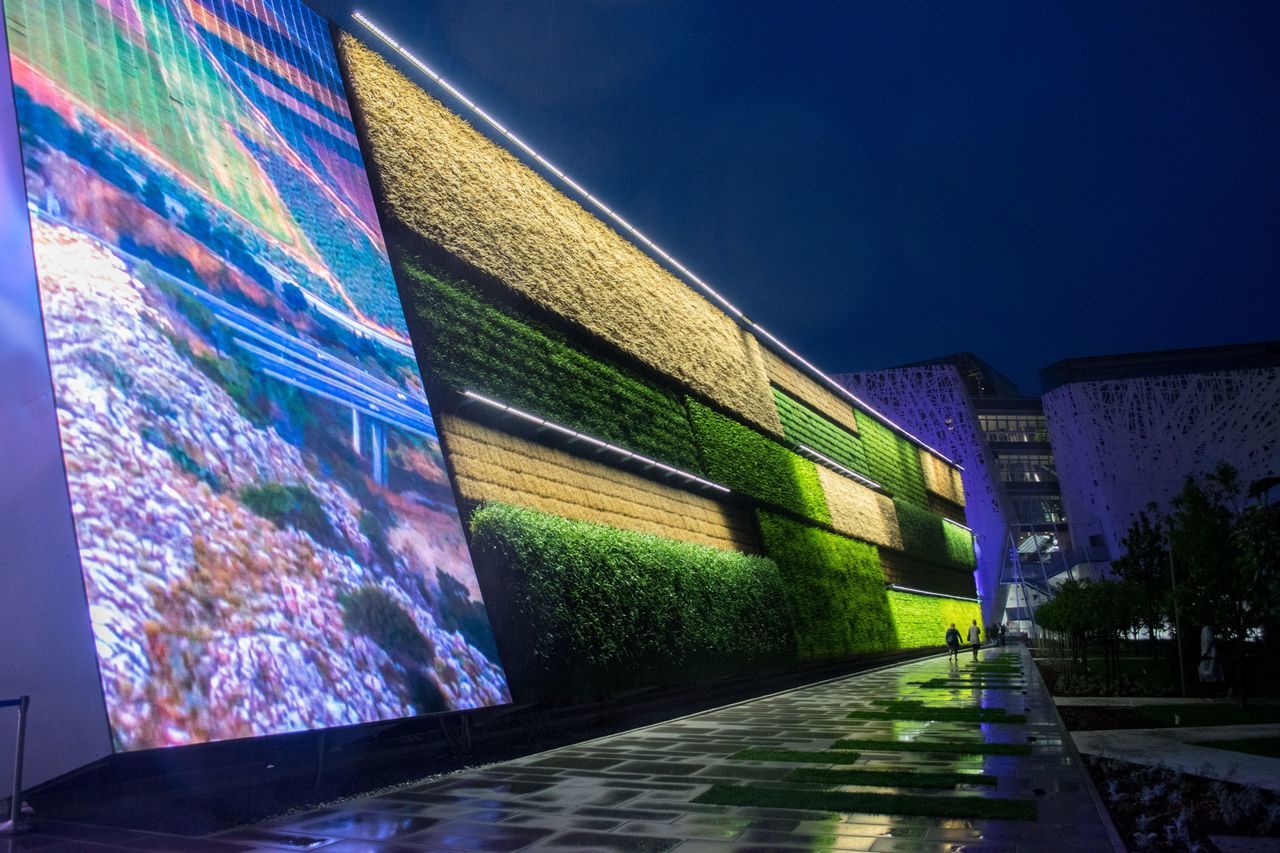 built structure, architecture, building exterior, illuminated, blue, wall - building feature, night, the way forward, graffiti, reflection, city, building, street, empty, diminishing perspective, no people, multi colored, outdoors, road, water