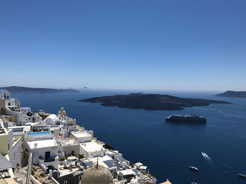 High angle view of town by sea against clear sky