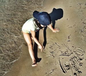 High angle view of girl drawing on shore