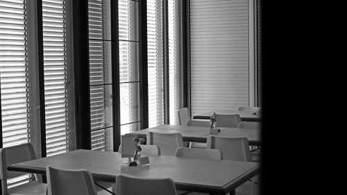 Empty chairs and tables in window