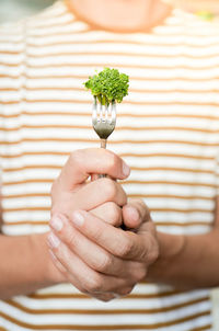 Midsection of woman holding flower