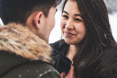 Close-up of young couple standing face to face during winter