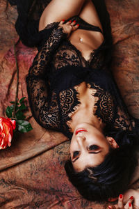 High angle view of sensuous young woman lying on bed