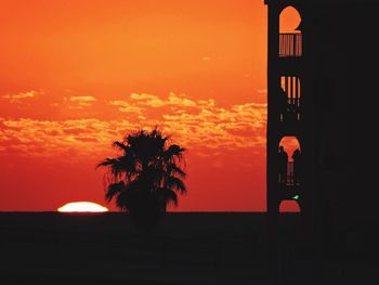Silhouette tree against orange sky